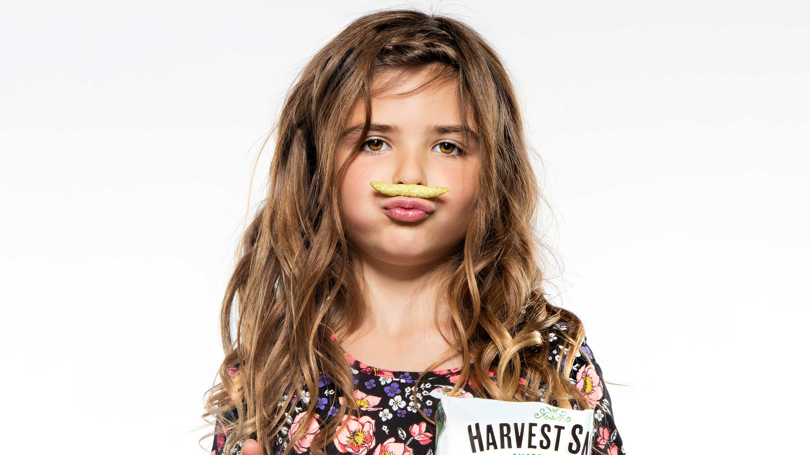 Girl with harvest snap sitting above upper lip