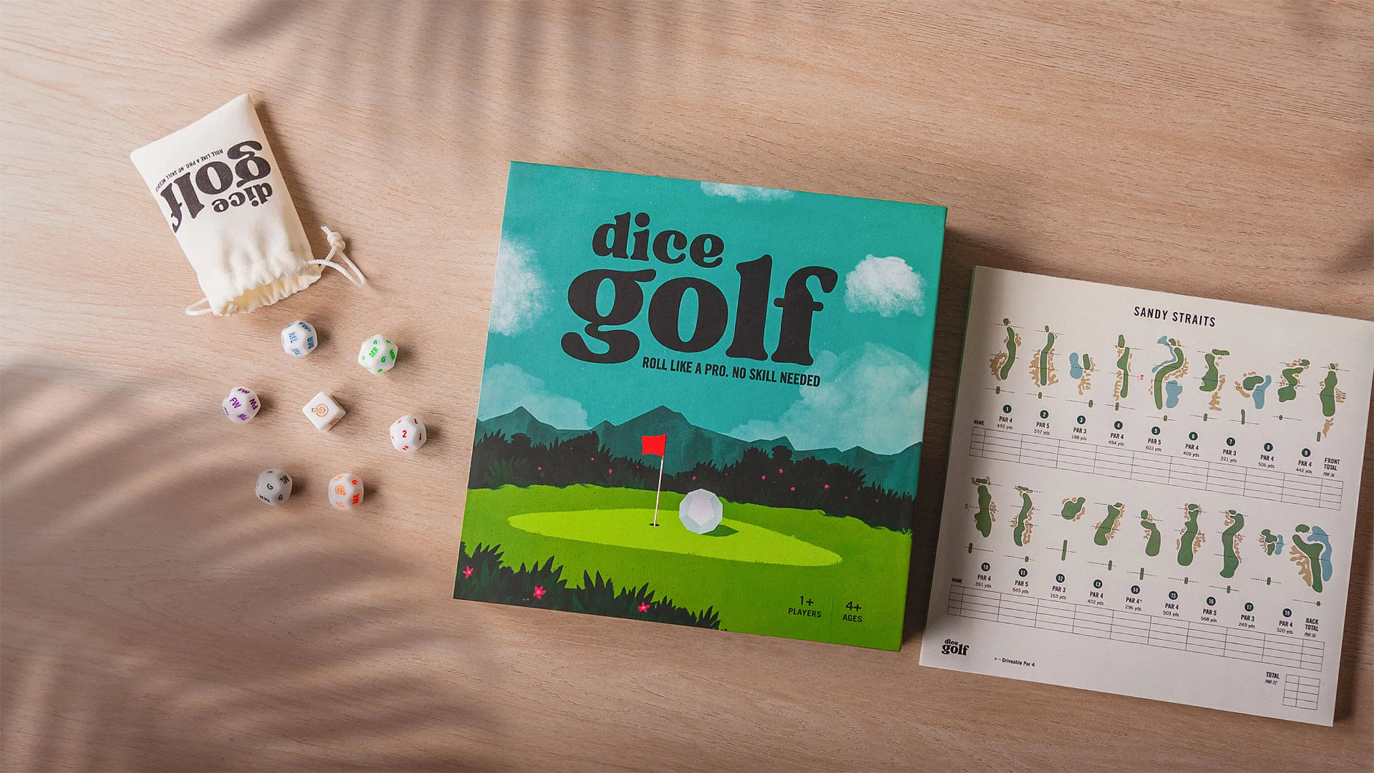 Dice Golf box, dice bag, dice, and the Sandy Straits scorecard laid out on wood