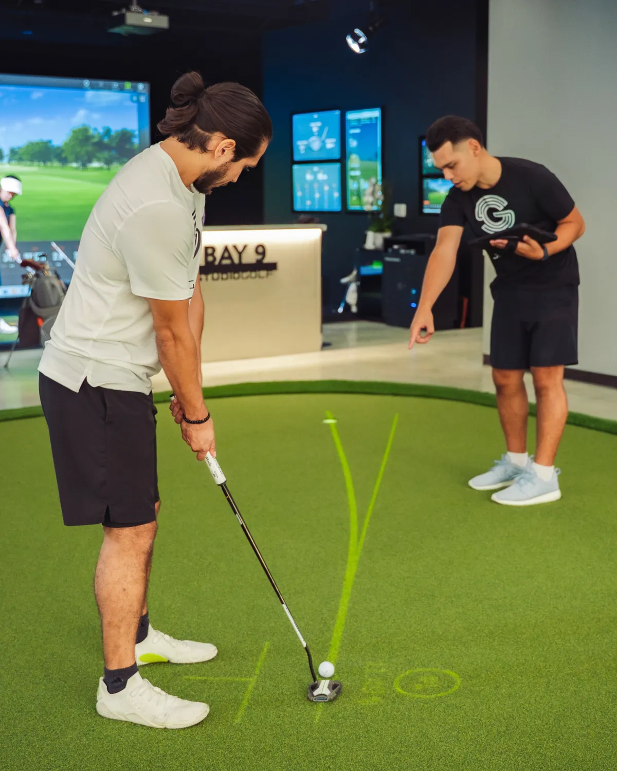 Golfer lining up a putt on an indoor simulator green at Studio Golf Club